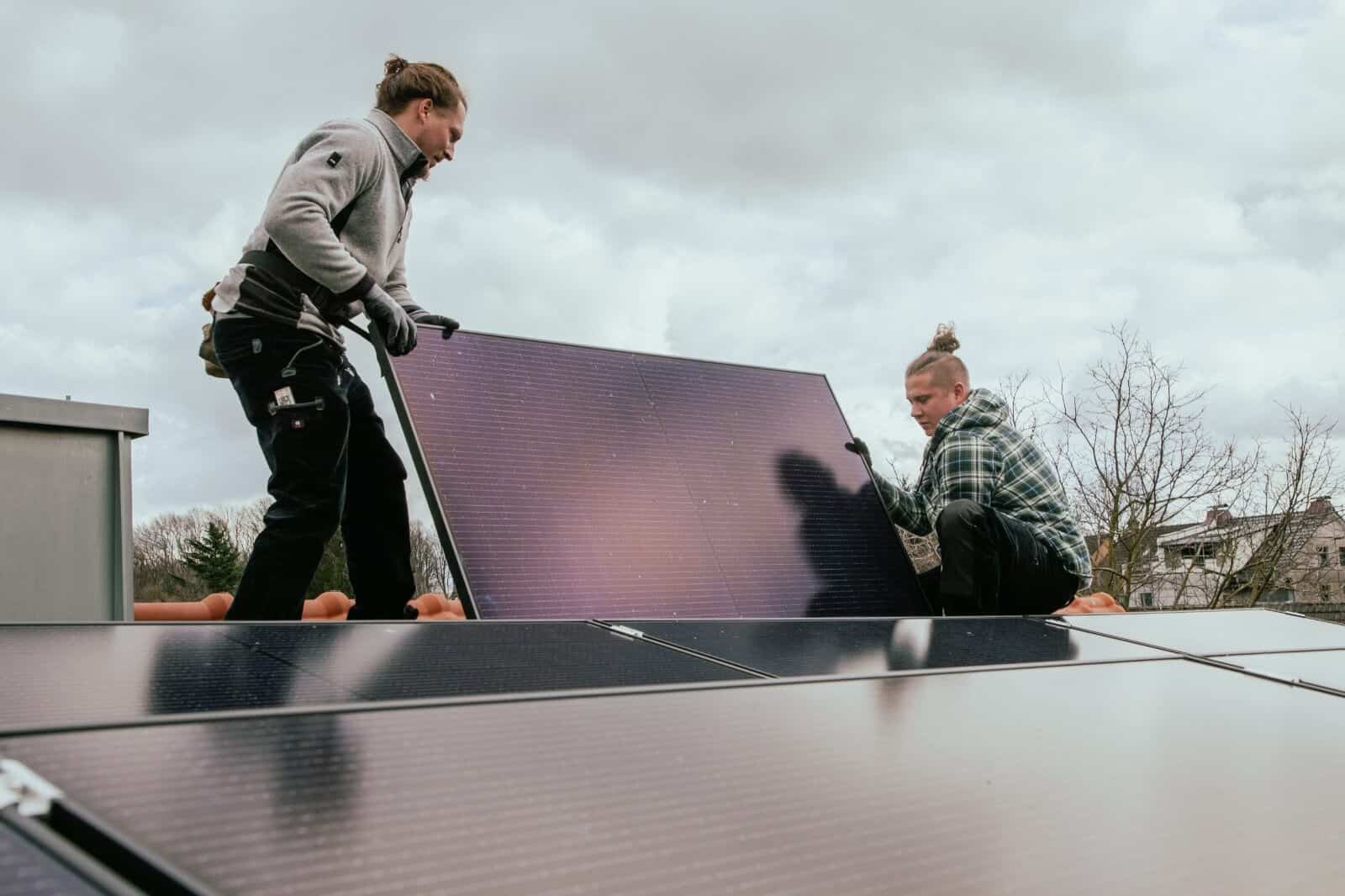 Joe Krohm und Alexander Schmidt montieren einen Solarpanel